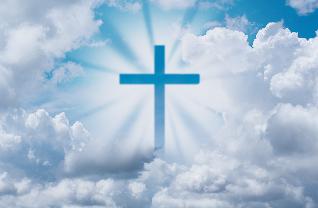 Cross in front of blue sky with clouds