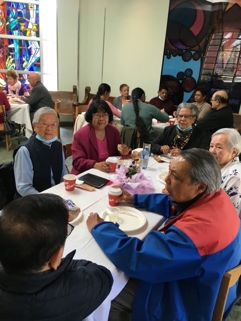Members sitting at tables during the Mother's Day gathering